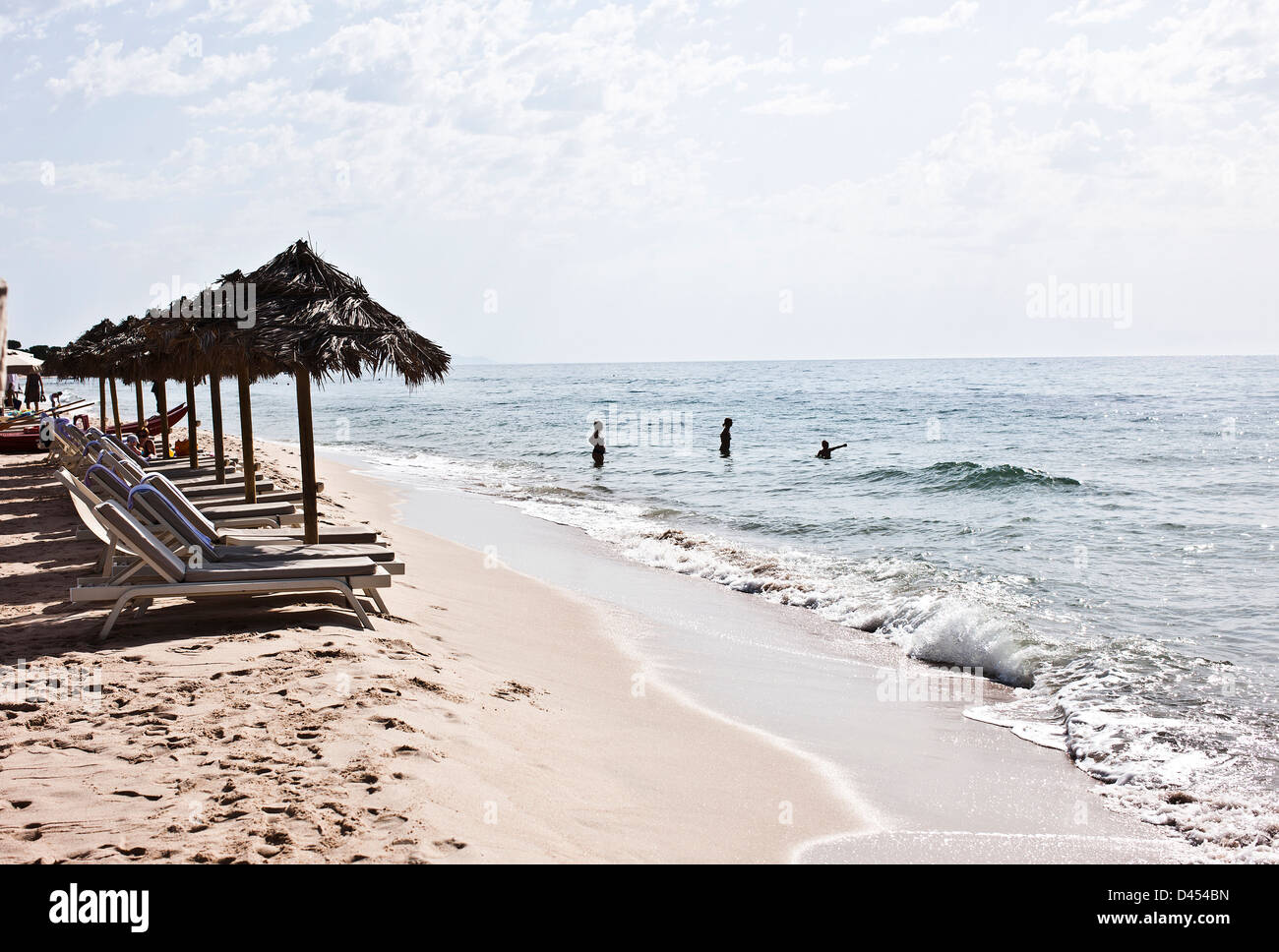 People in sea with parasols and sunloungers, Sardinia, Italy Stock Photo