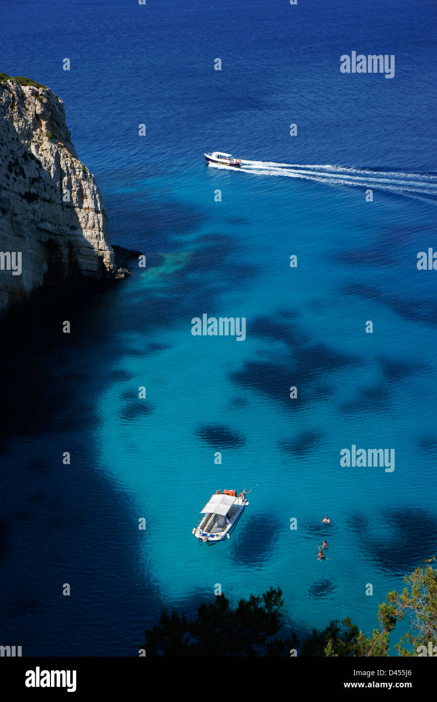 Pleasure boats with people swimming in ocean at Blue Caves cliffs, Island Zakynthos, Greece Stock Photo