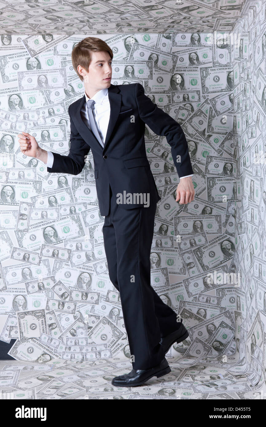 a businessman running away from a dollar room Stock Photo - Alamy