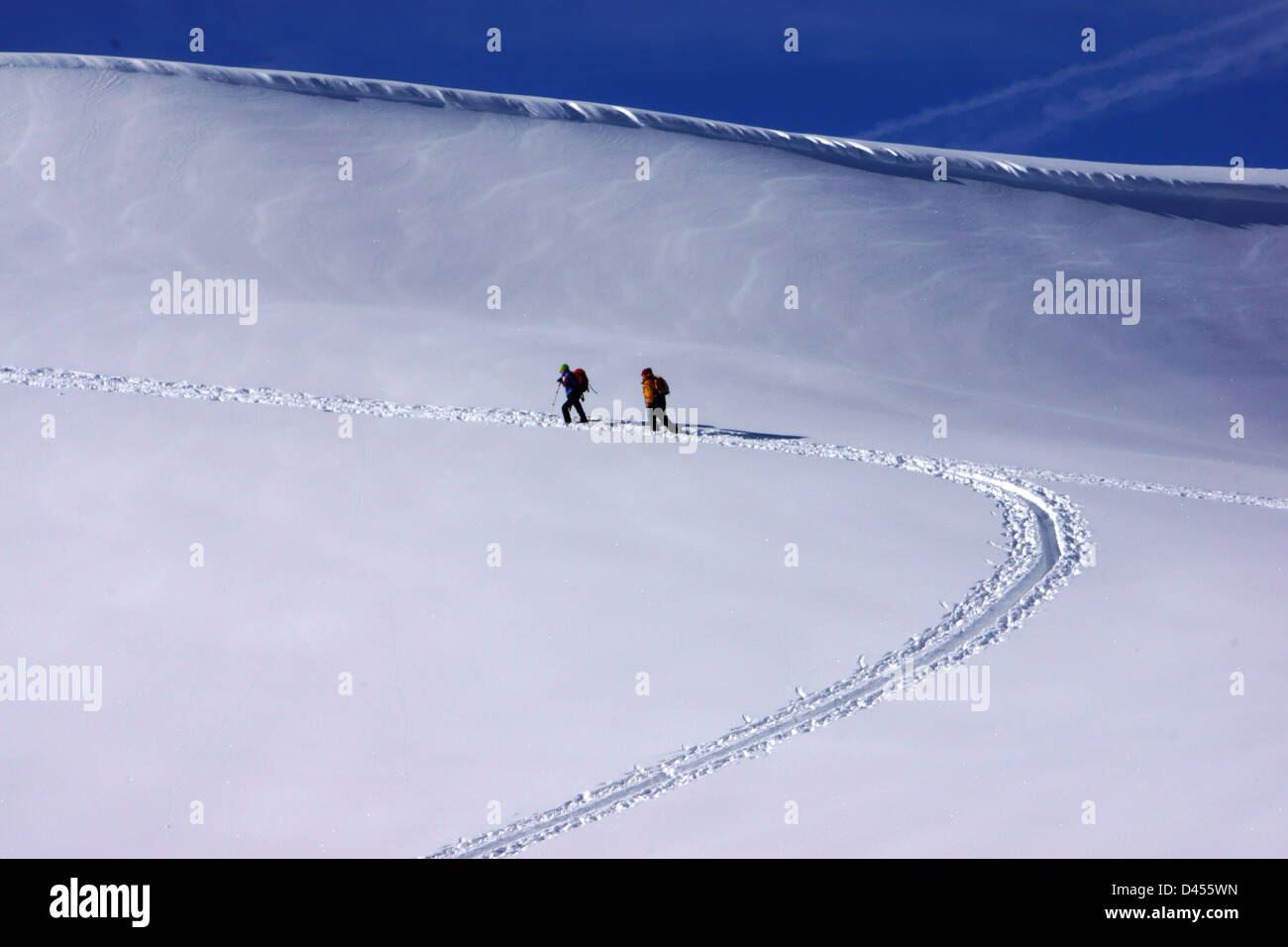 Backcountry skiers walking up Standflue, Bernese alps, Switzerland Stock Photo