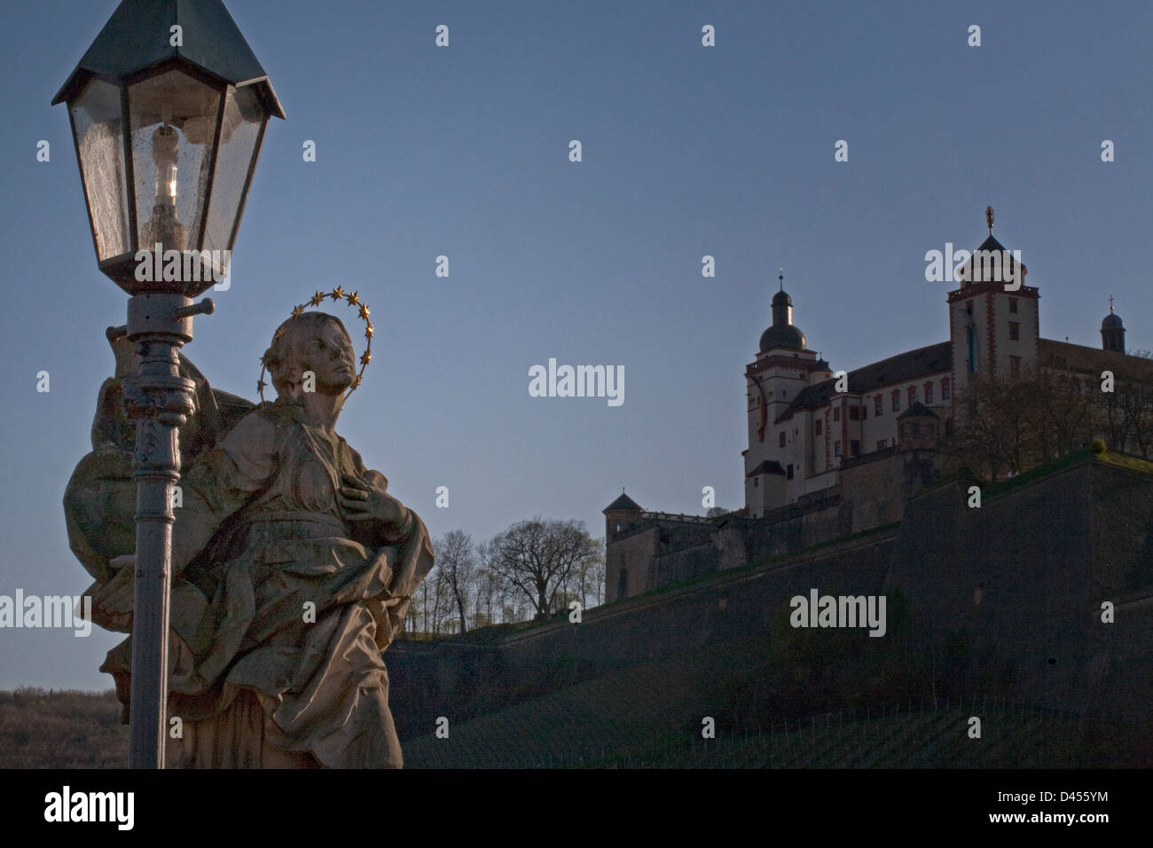 Statue on the Alte Mainbrucke, Wurzburg Germany and the Marienberg (Mary's hill) on the background. Stock Photo