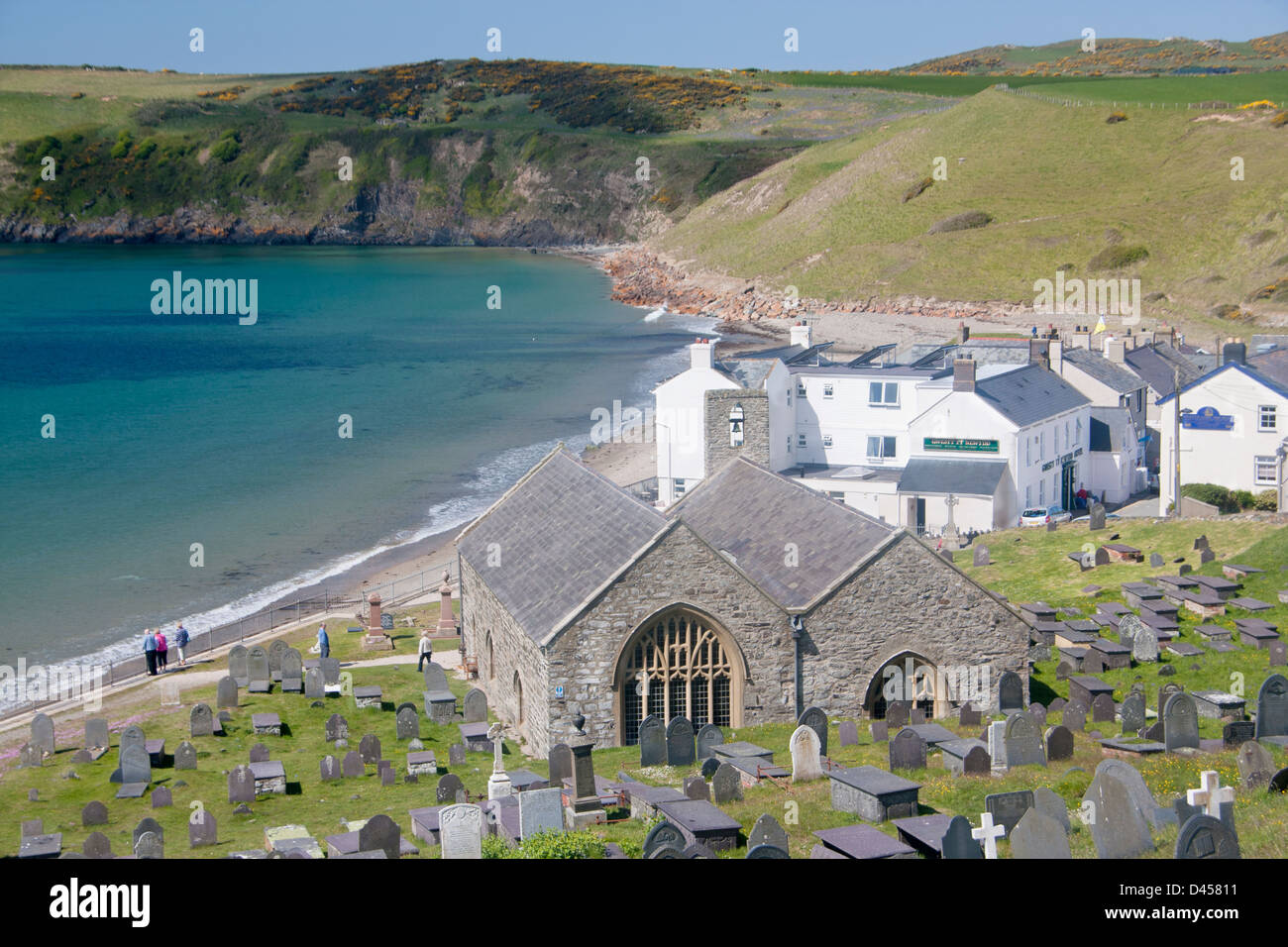 St Hywyn's Church and churchyard with beach and bay behind Aberdaron Llŷn Peninsula Gwynedd North Wales UK Stock Photo