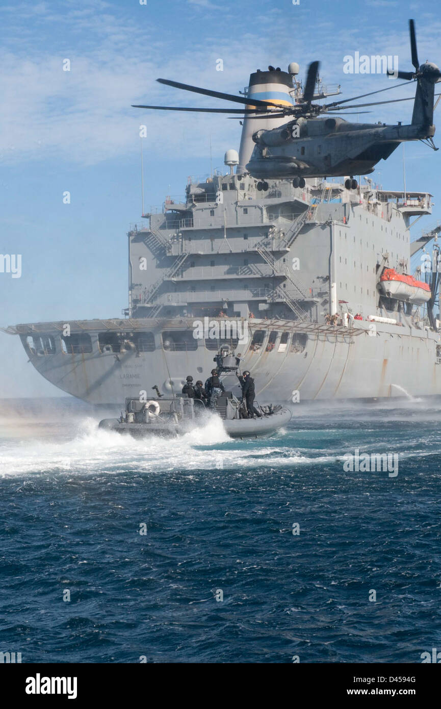 Sailors head toward the Military Sealift Command fleet replenishment oiler USNS Laramie (TAO