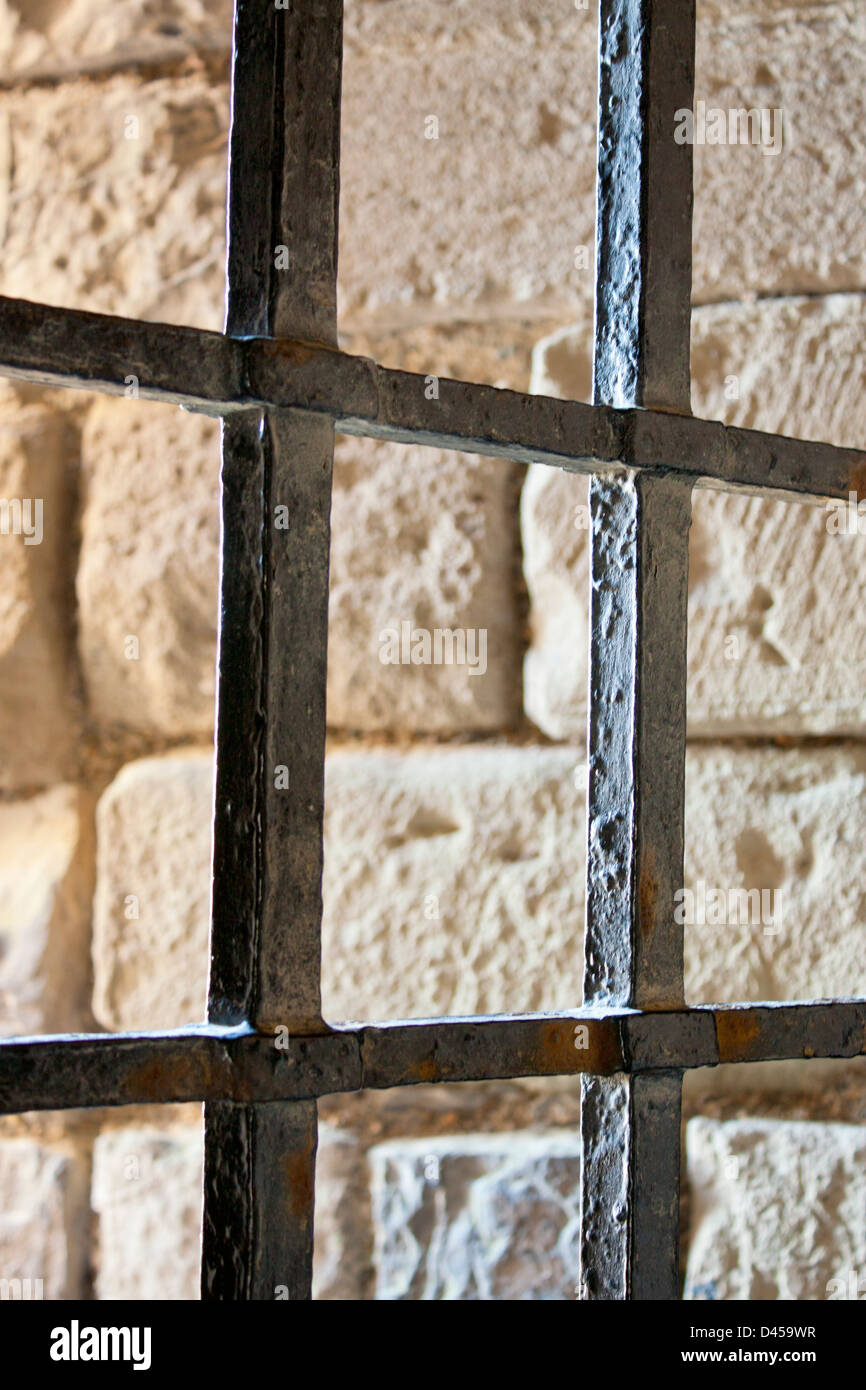 Prison bars on window in Caernarfon Castle with stone background Gwynedd Wales UK Stock Photo