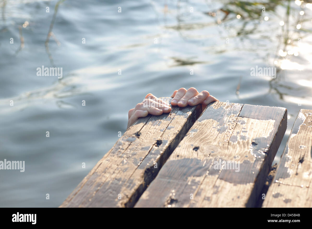 Manos agarrandose en un embarcadero en el lago de Banyoles Stock Photo