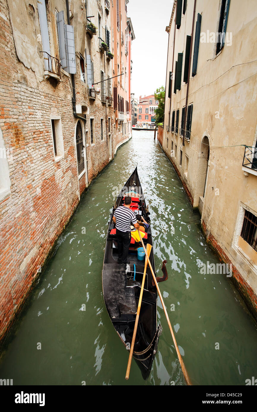 A gondola running by the channel in Venice Stock Photo - Alamy