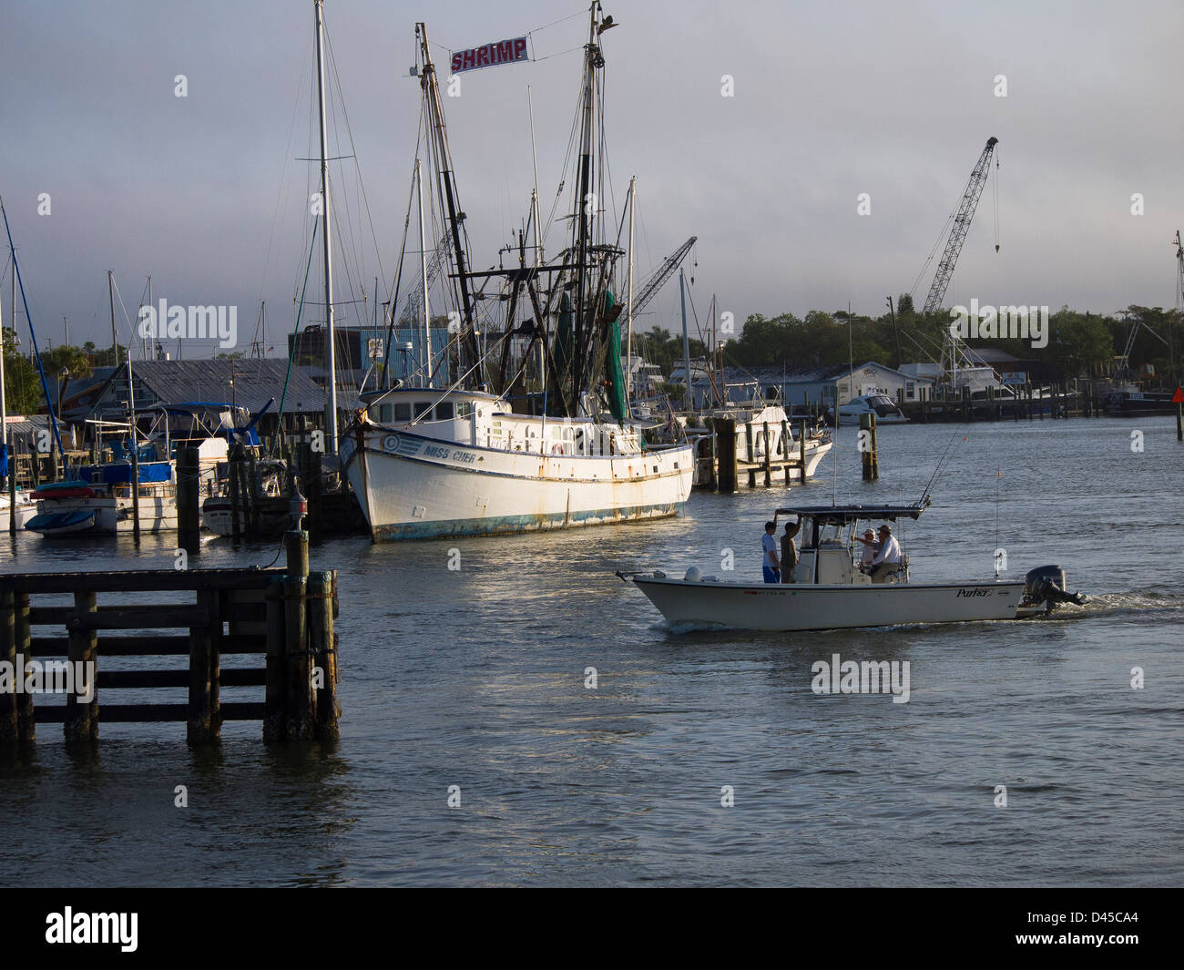 Fishermen head out to fish in the Gulf of Mexico going past a commercial fishing boat at the tip of Fort Myers Beach in Florida Stock Photo