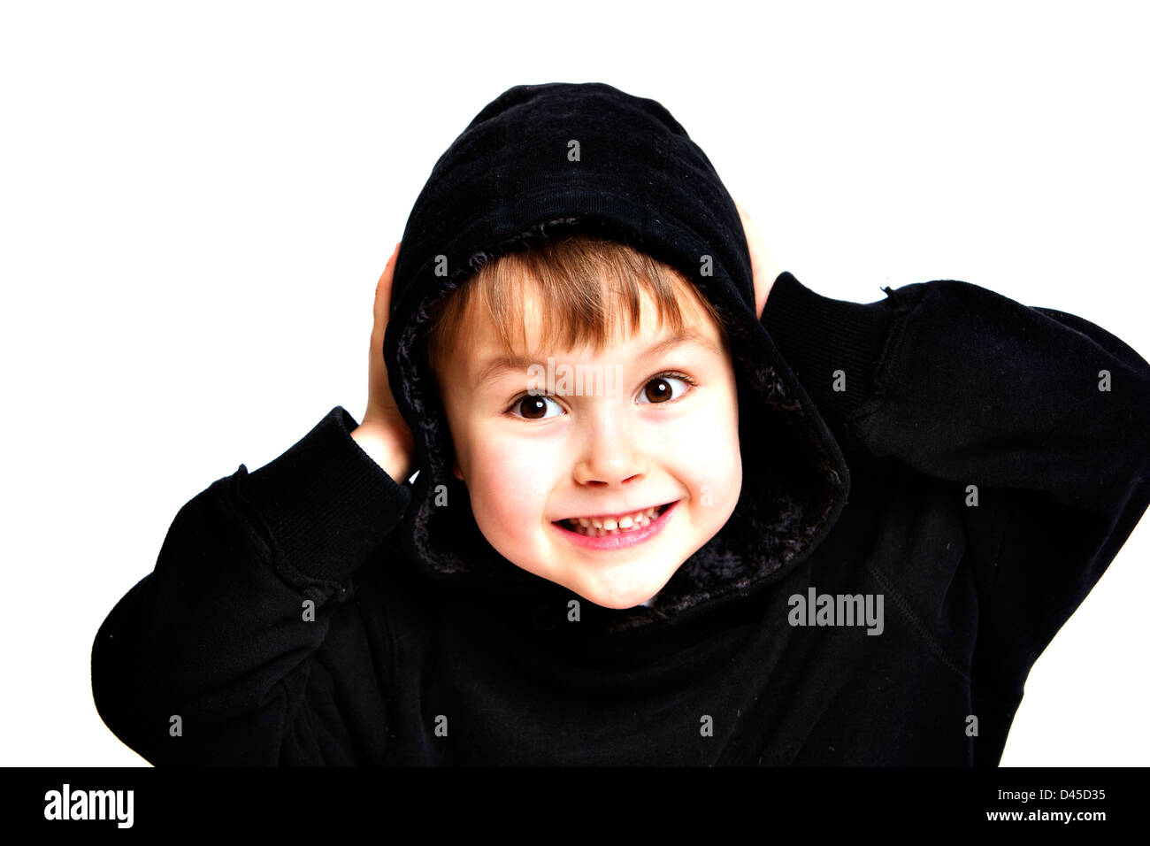 Young boy in a black hoodie sweatshirt with sallow skin brown hair and brown eyes against a white background making faces for the camera Stock Photo