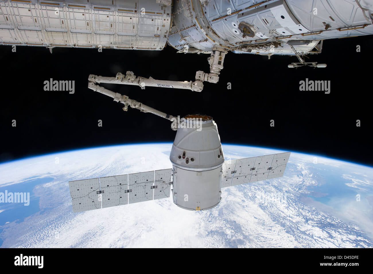 View of the SpaceX Dragon capsule captured by the robotic arm of the ...