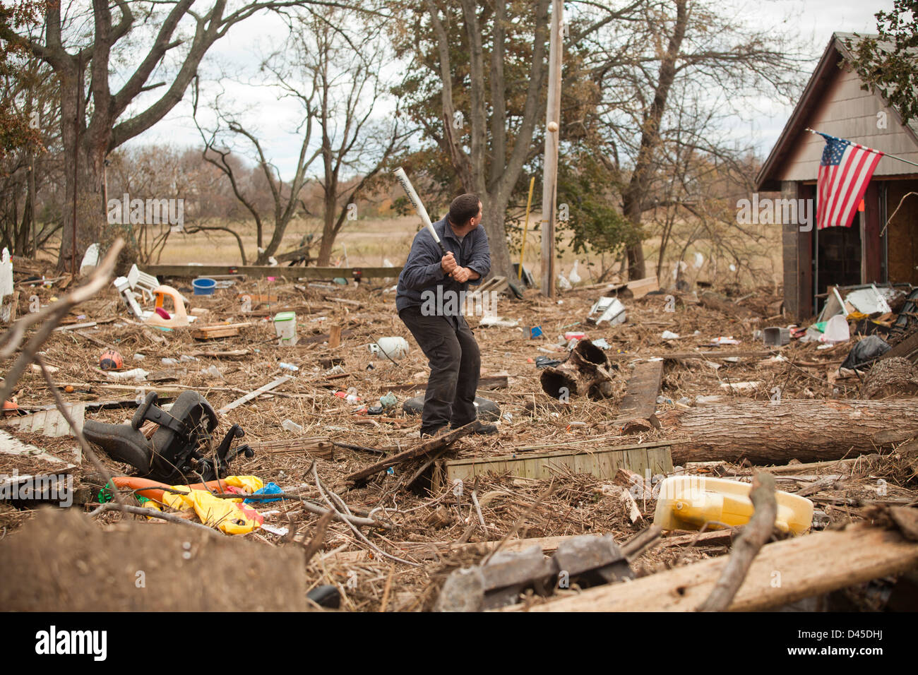 Neighbors play baseball over the wreckage from Superstorm Sandy - including cars, roofs, and house-walls in Union Beach, NJ Stock Photo