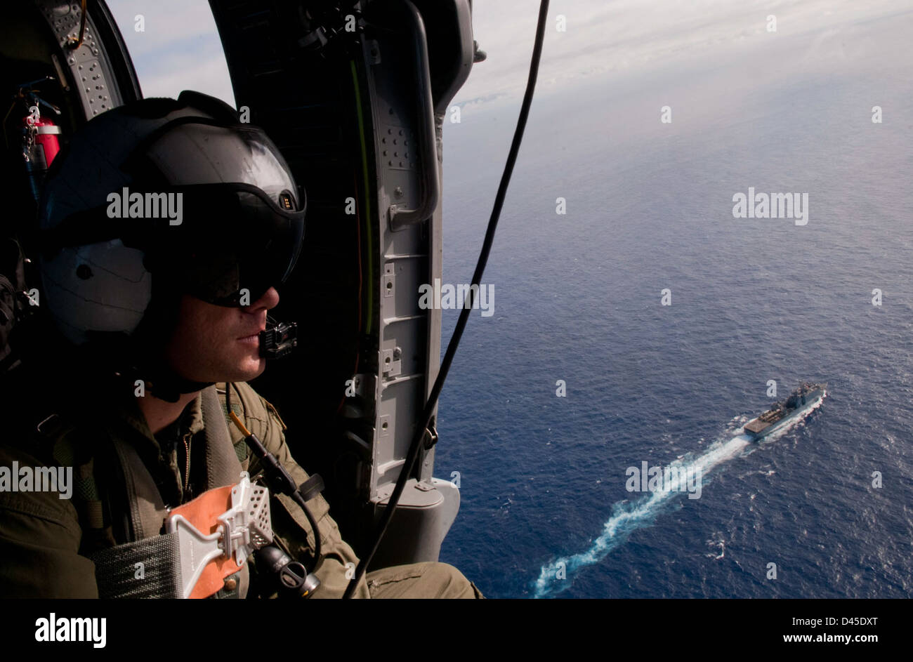 Aircrewman watches ships from the air. Stock Photo