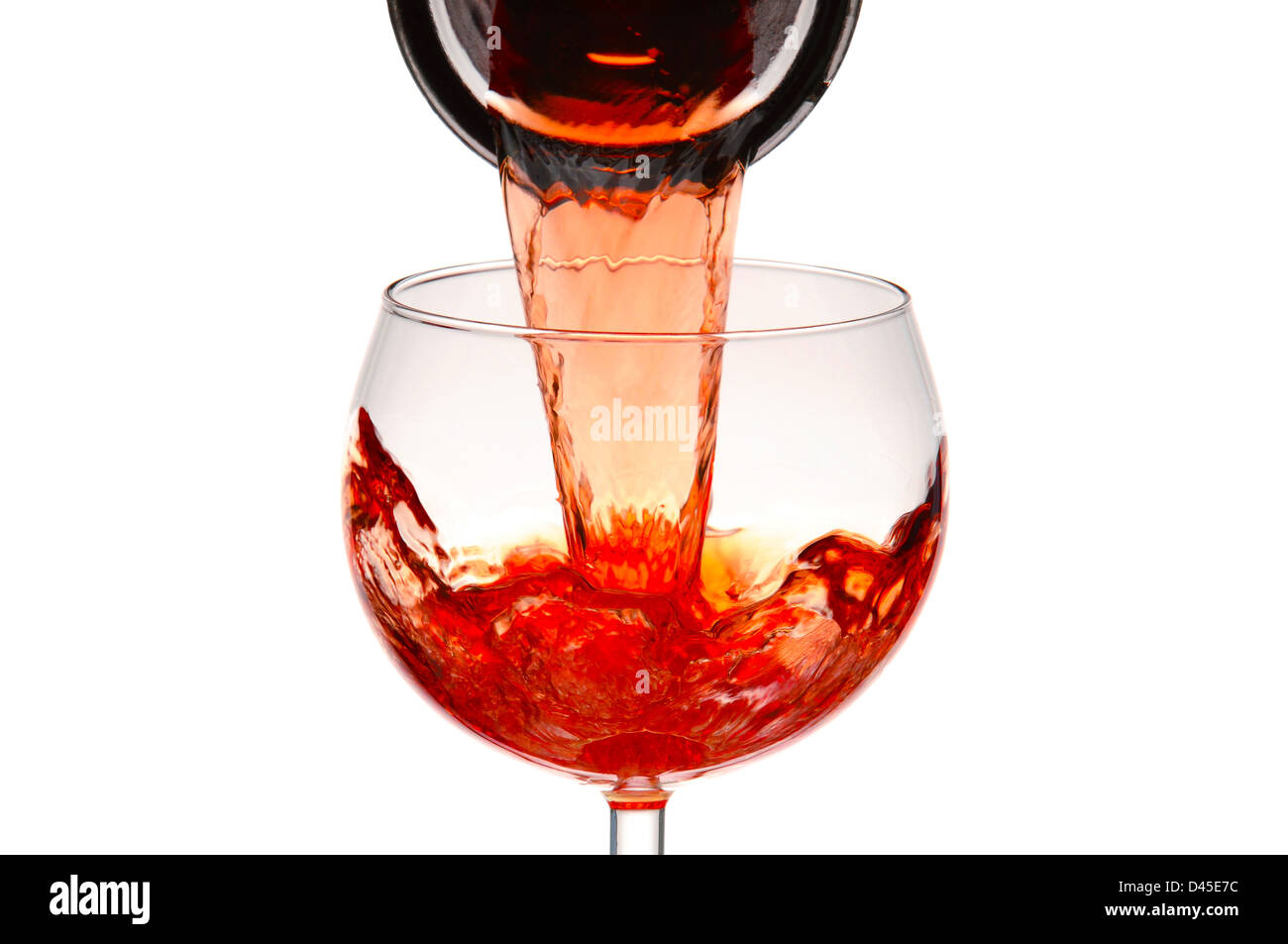 Closeup of a wineglass with red wine pouring from a carafe. Stock Photo