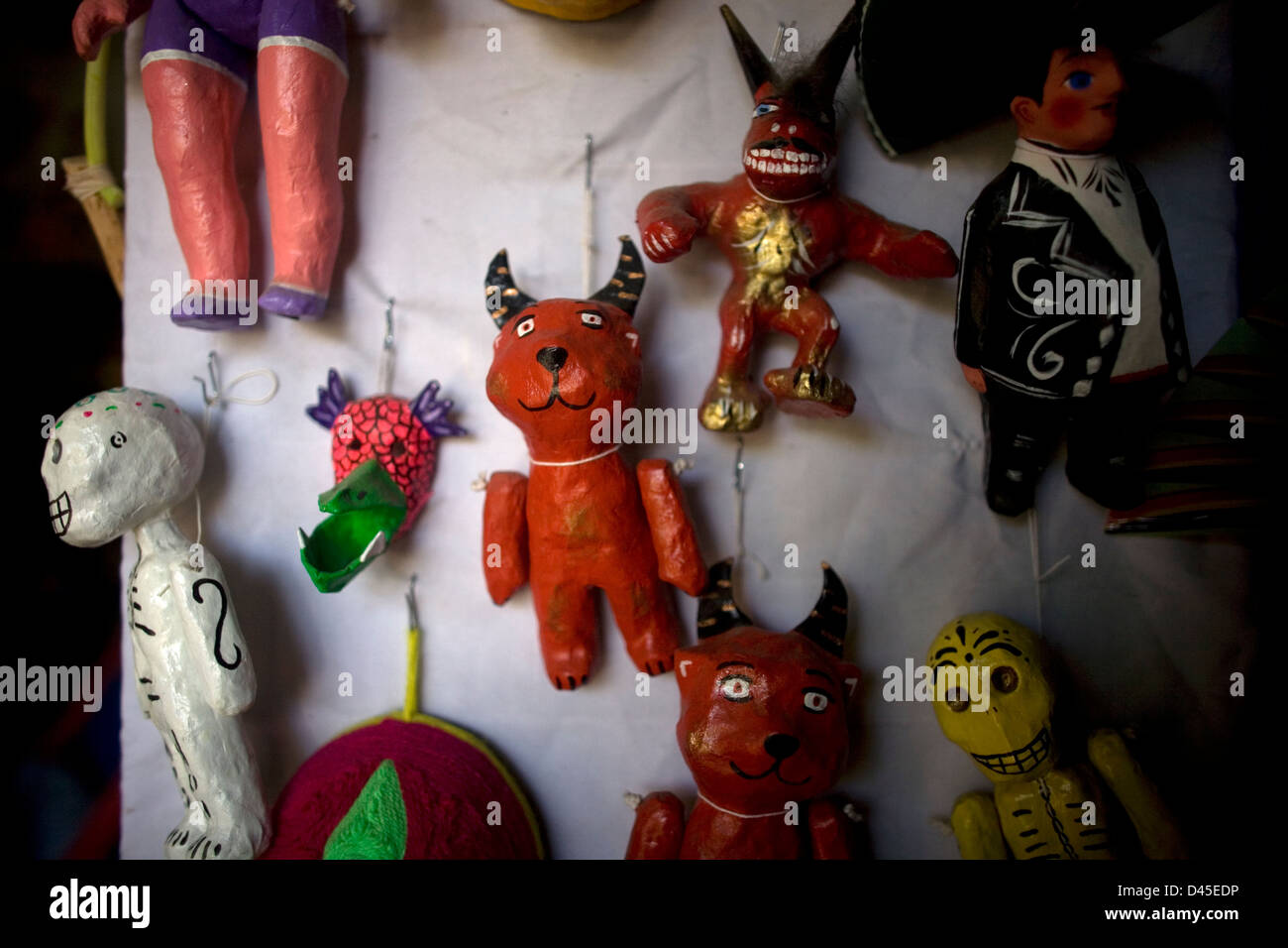 Paper mache dolls representing red devils and skeletons sit for sale in a Mexican folk-art workshop. Stock Photo
