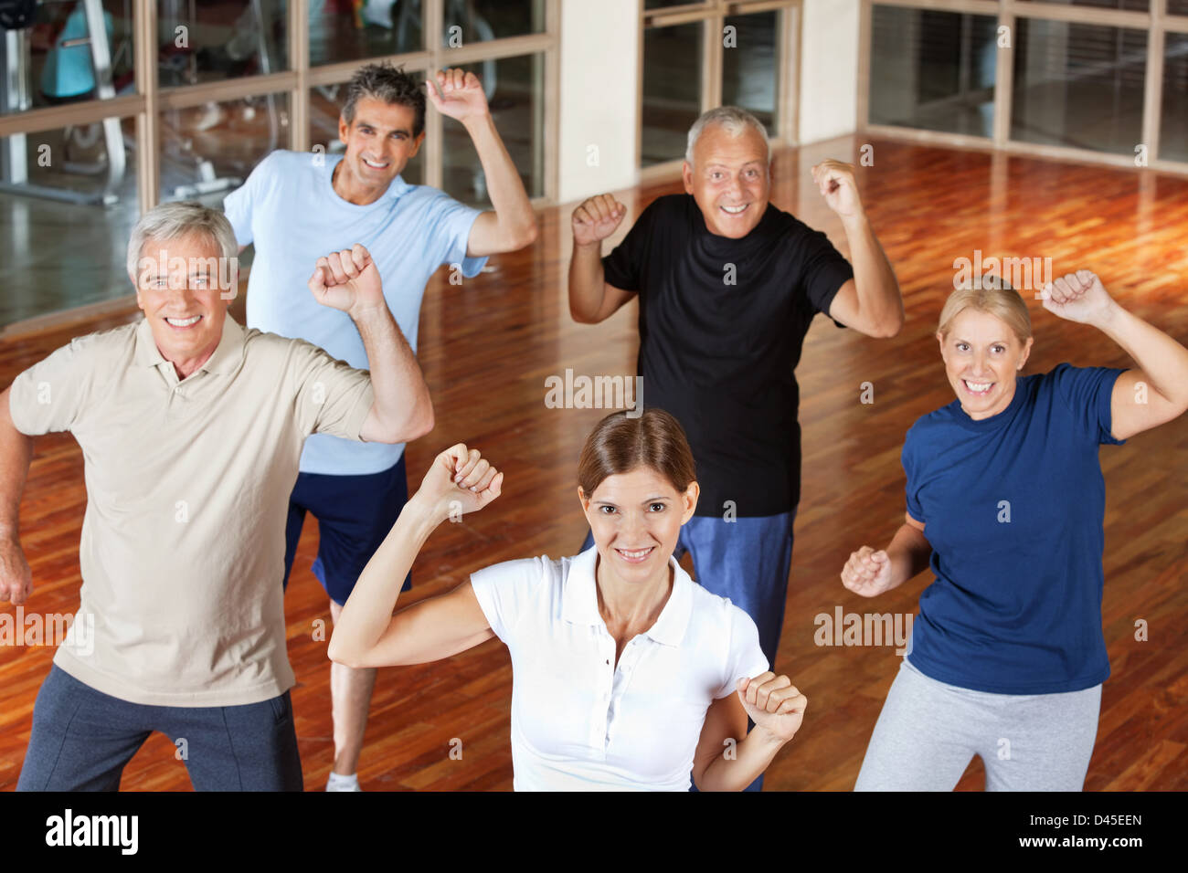 Happy senior group moving and dancing in fitness center Stock Photo