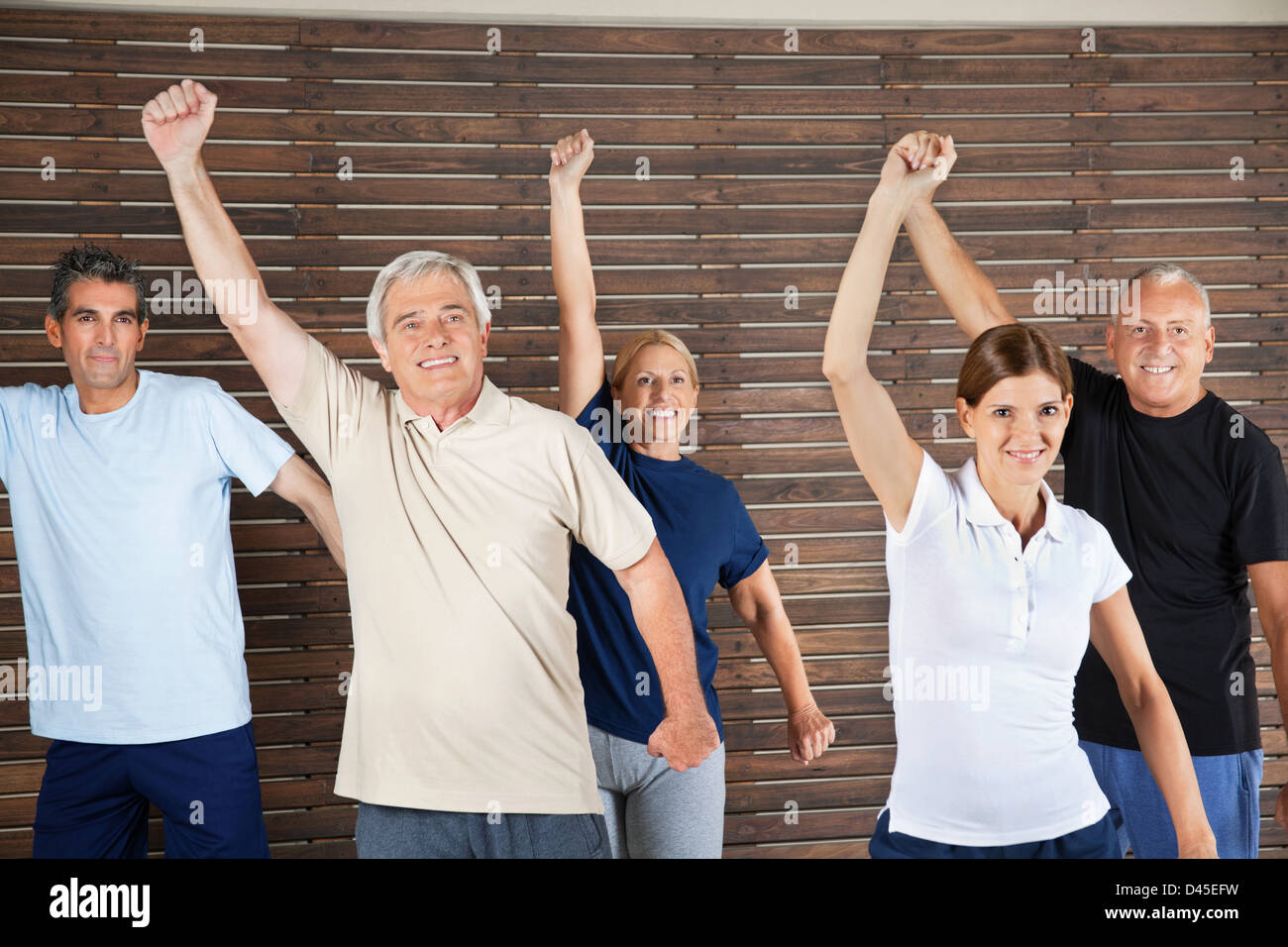 Happy senior citizens dancing to fitness music in gym Stock Photo