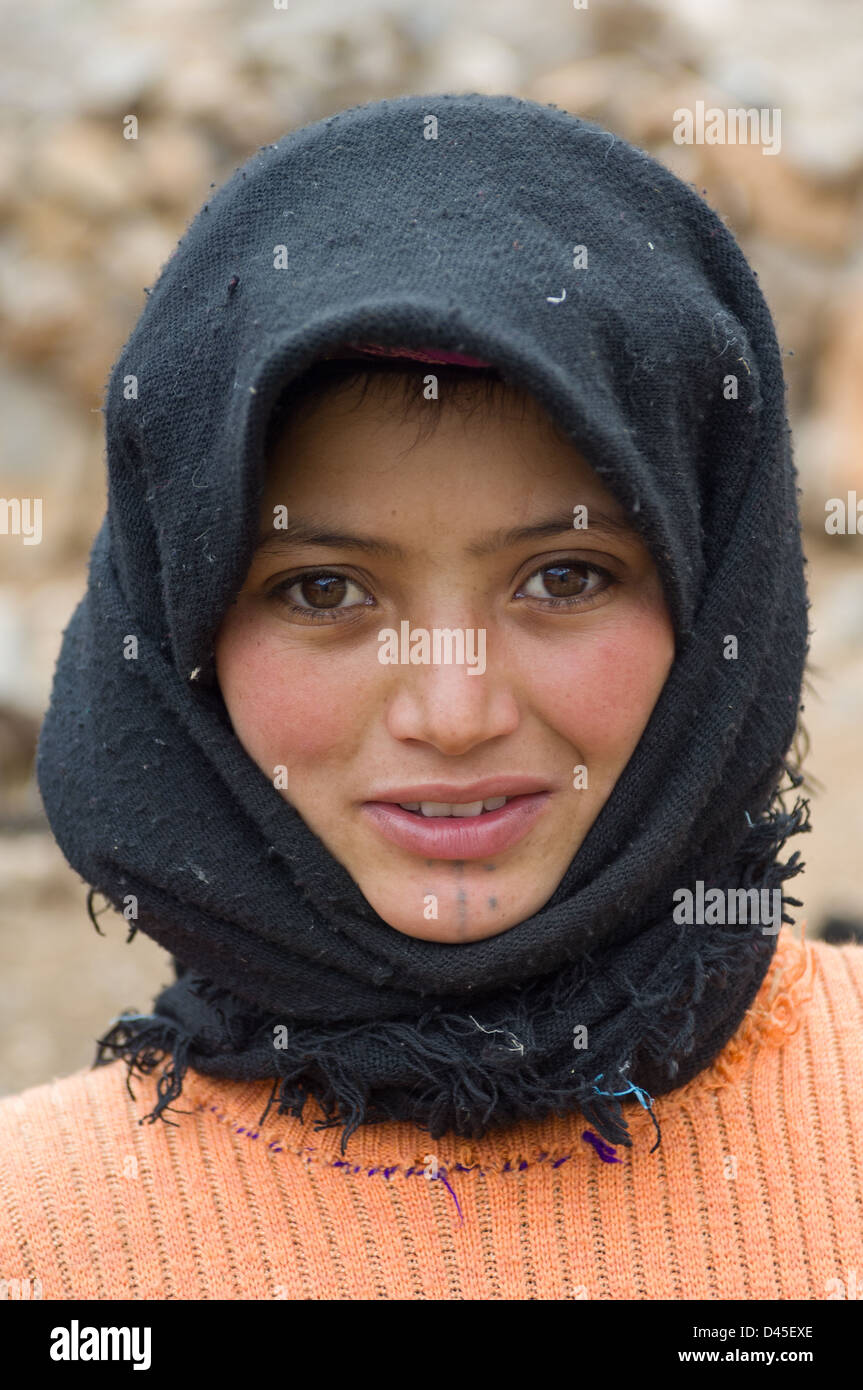 Berber girl with a facial tattoo on her chin and a black headscarf, near Todra Gorge, Morocco Stock Photo