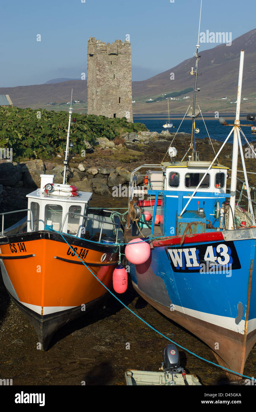 Small fishing boats moored in front of Grace O'Malley's Tower (Kildavnet Castle) a 16th century tower on Achill Island, Westport, County Mayo, Ireland Stock Photo