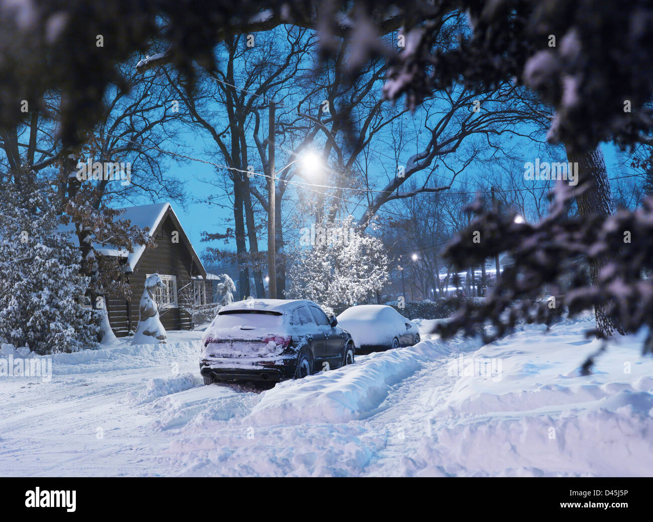 Cars on a snow covered city street after a storm. Wintertime scenery, Toronto, Ontario, Canada. Stock Photo
