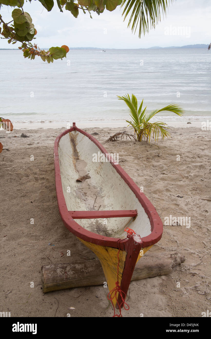 Traditional, dugout canoe / cayuco on the shore at Carenero Island. Stock Photo