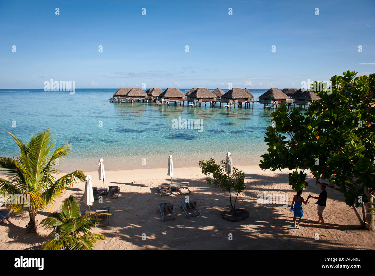 Beach and over-water thatch bungalos, French Polynesia Stock Photo