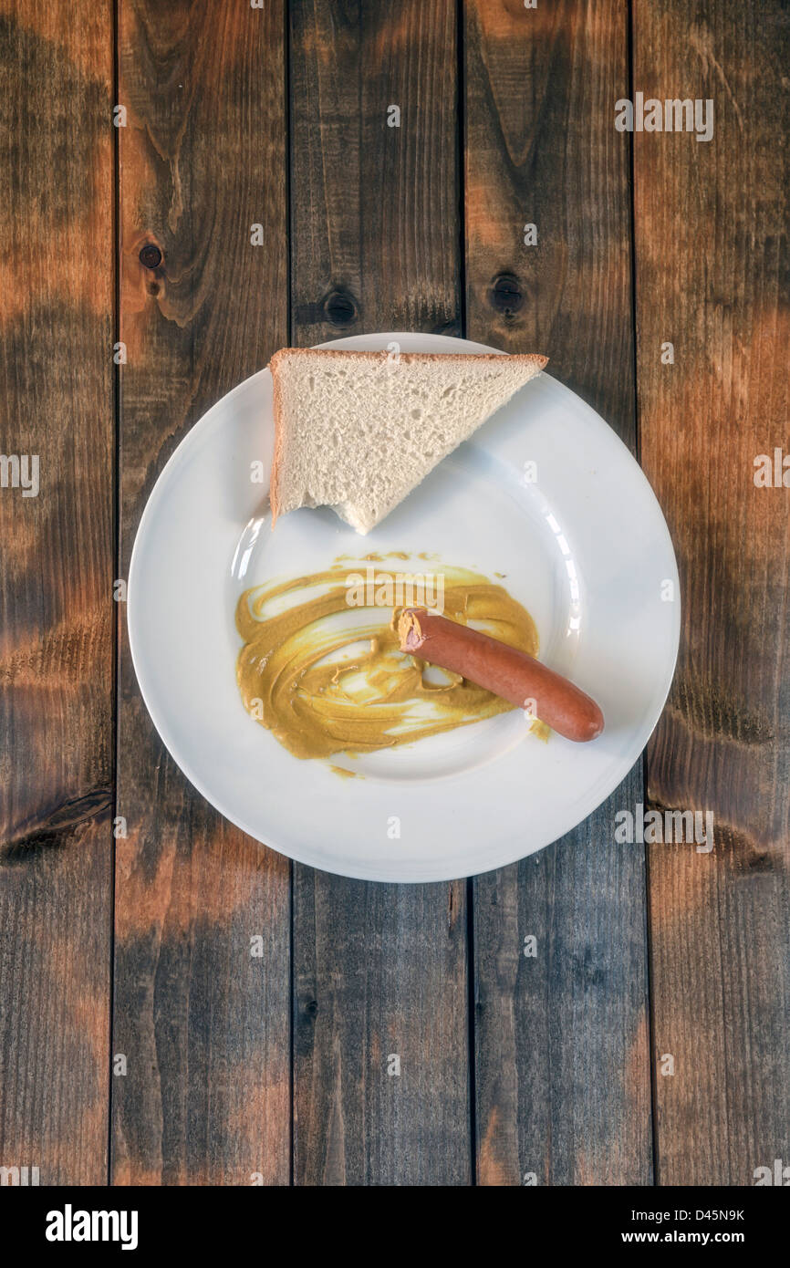 half eaten wiener with mustard and toast Stock Photo