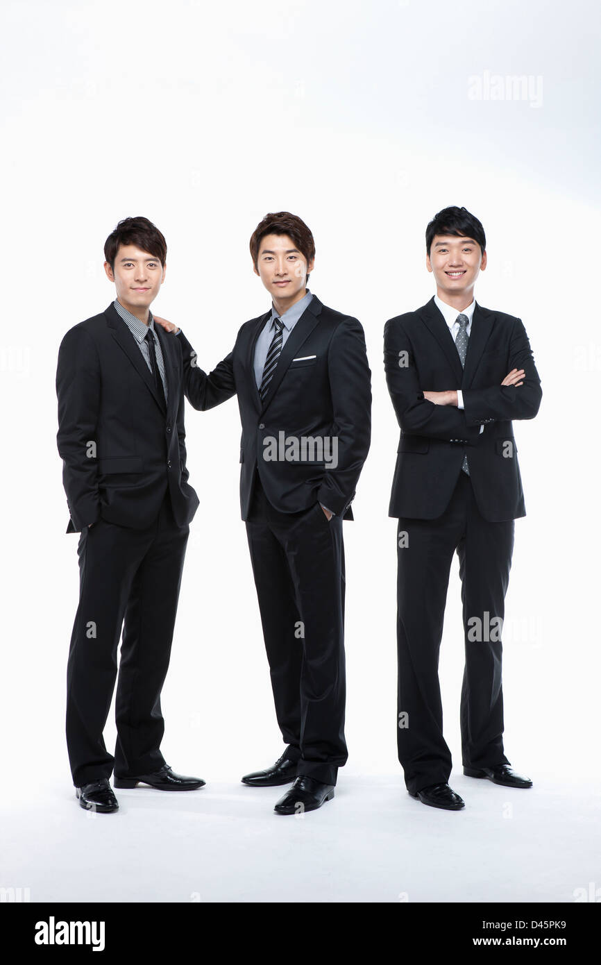 three businessmen in buisness suits posing in a line Stock Photo - Alamy