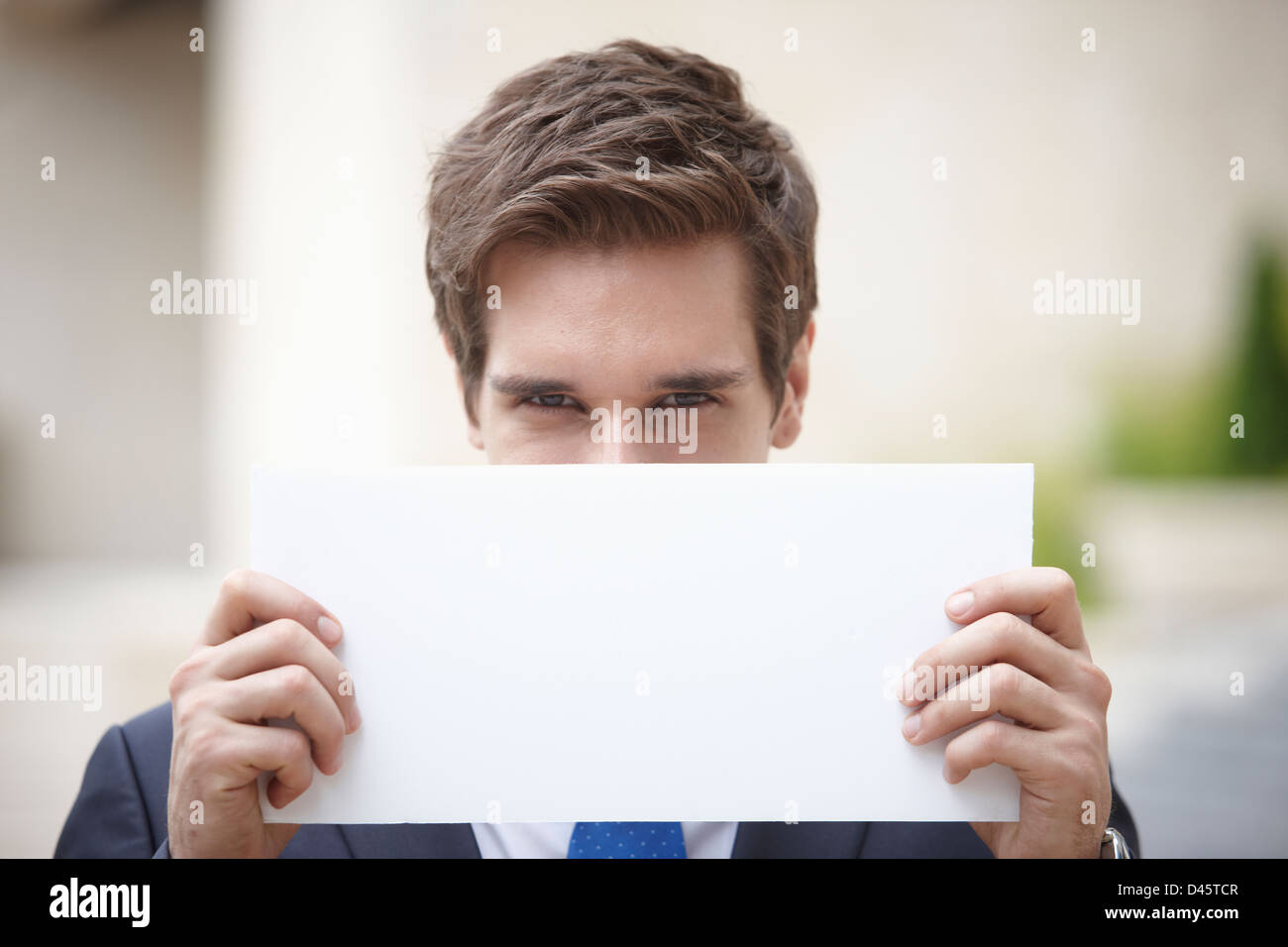 a western businessman holding a white empty paper Stock Photo - Alamy