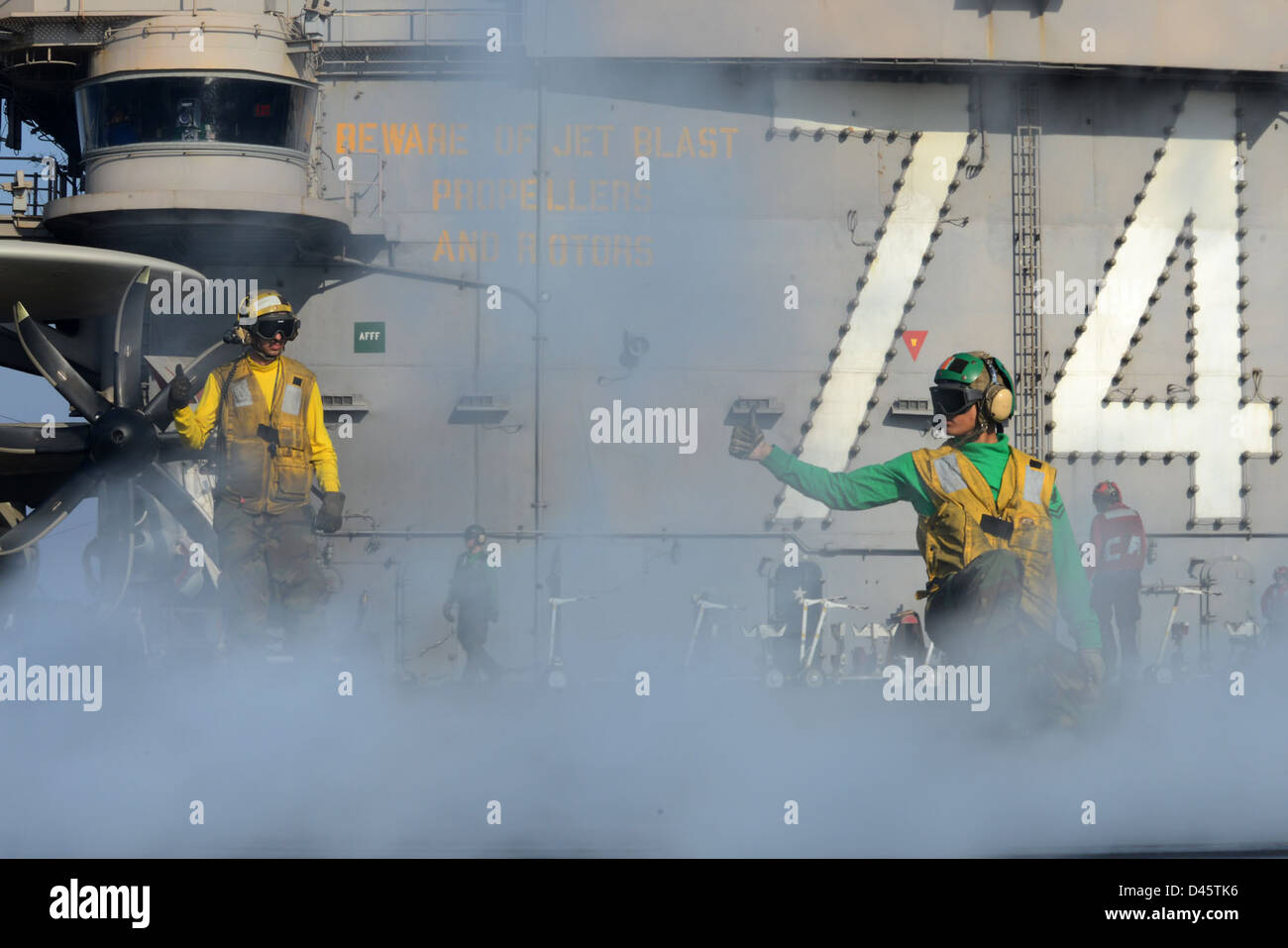Sailors signal to launch an aircraft at sea Stock Photo - Alamy
