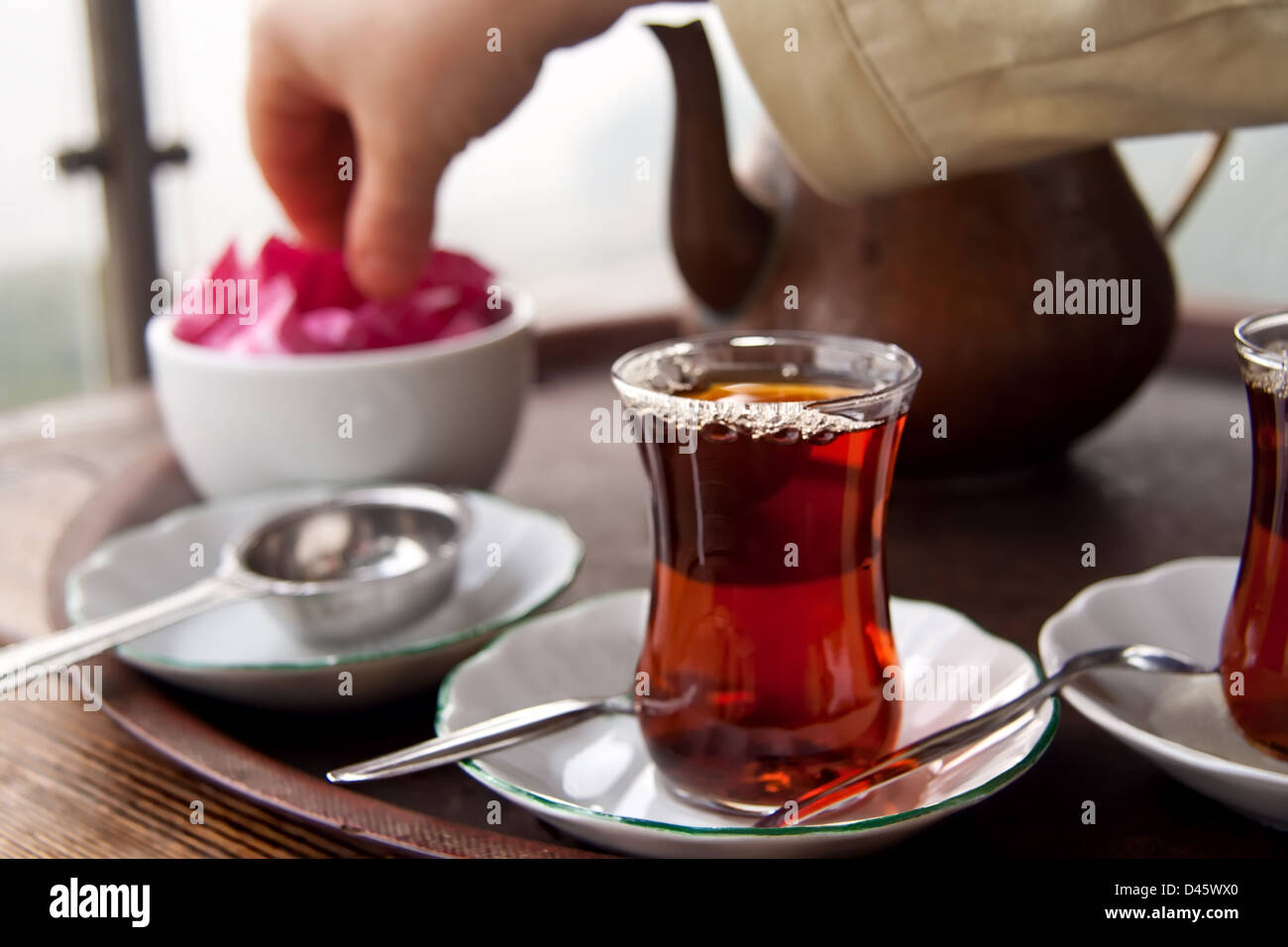 Drinking traditional Turkish Tea with Turkish tea cup and copper tea pot, and eating tost with friends. Stock Photo