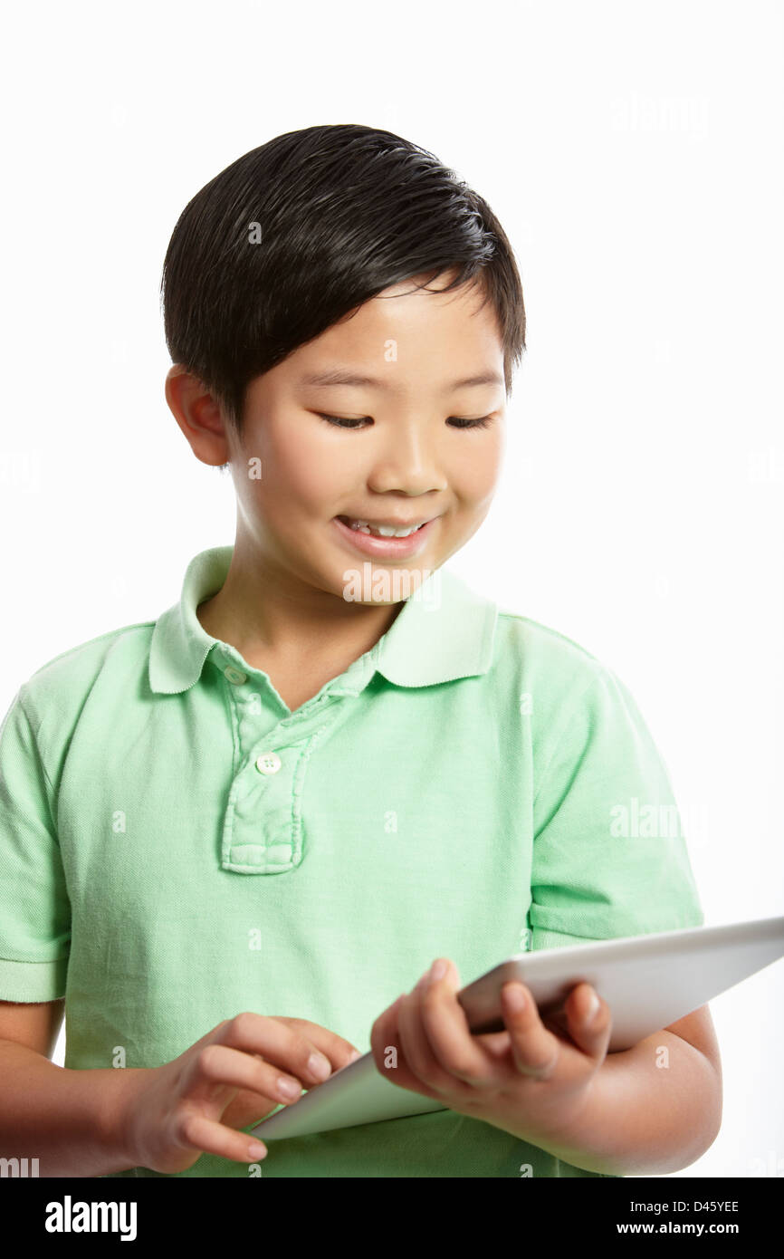 Studio Shot Of Chinese Boy With Digital Tablet Stock Photo