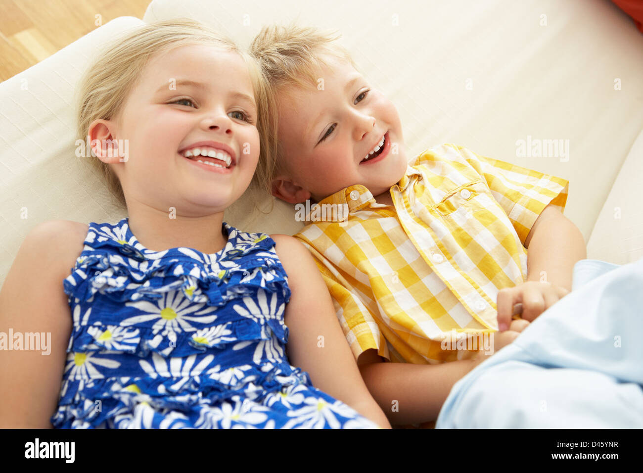 Two Children Lying Upside Down On Sofa At Home Stock Photo Alamy