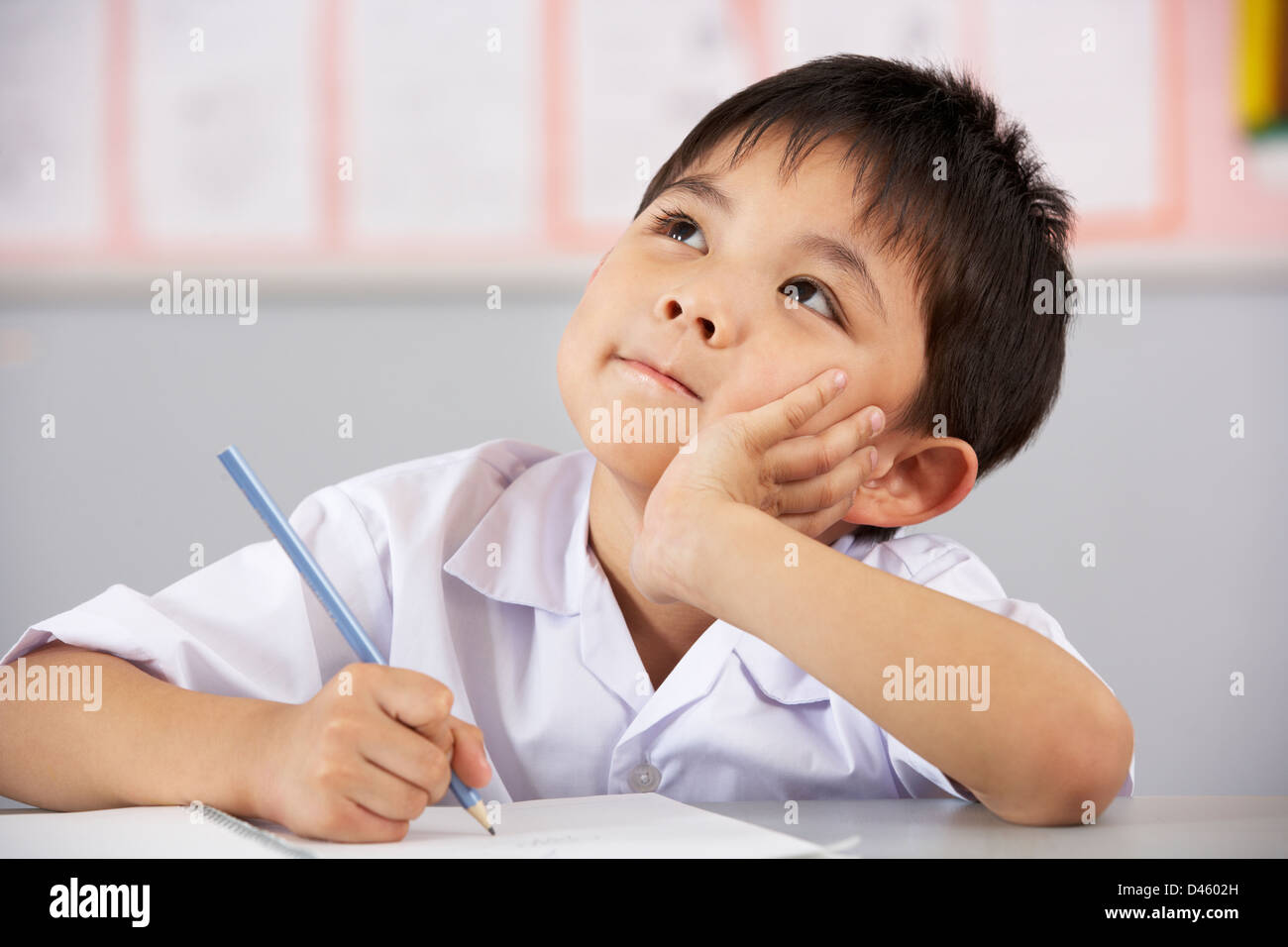 Male Student Working At Desk In Chinese School Classroom Stock Photo ...