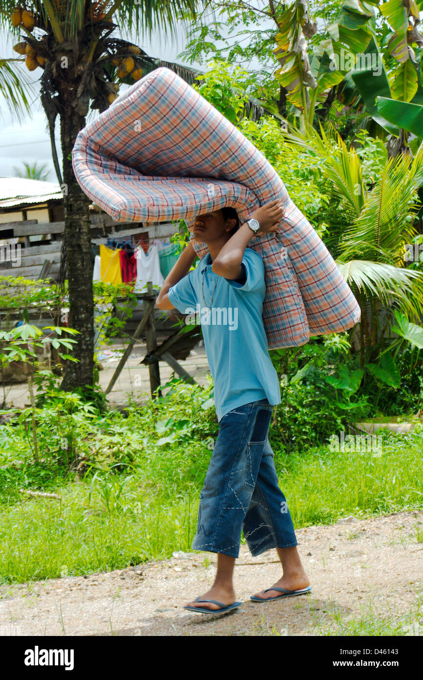 Boy walking with mattress, Paramaribo, Surinam Stock Photo Alamy