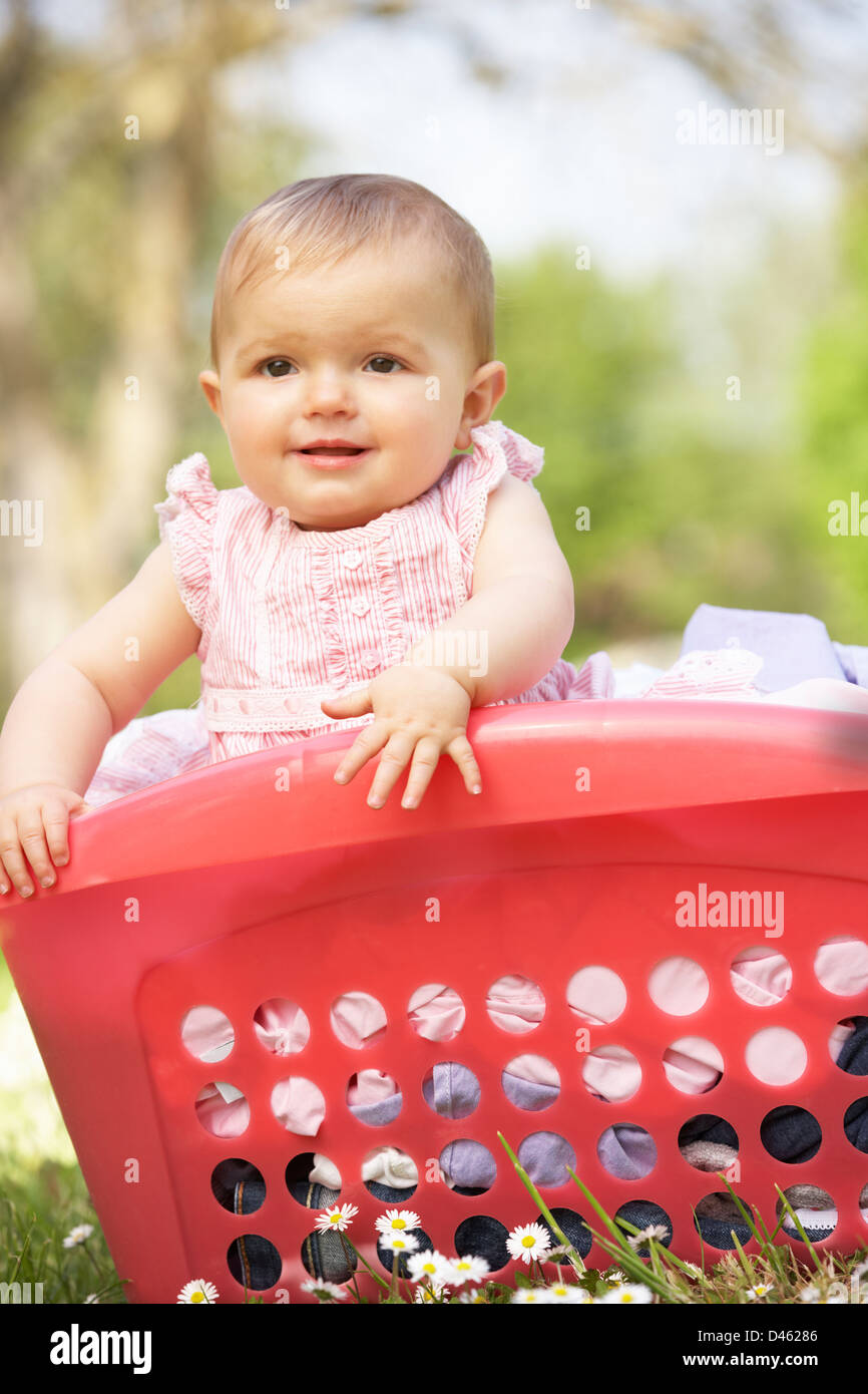 Baby Girl In Summer Dress Sitting In Laundry Basket Stock Photo Alamy