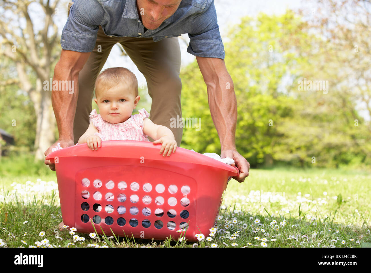 Father Carrying Baby Girl Sitting In Laundry Basket Stock Photo Alamy