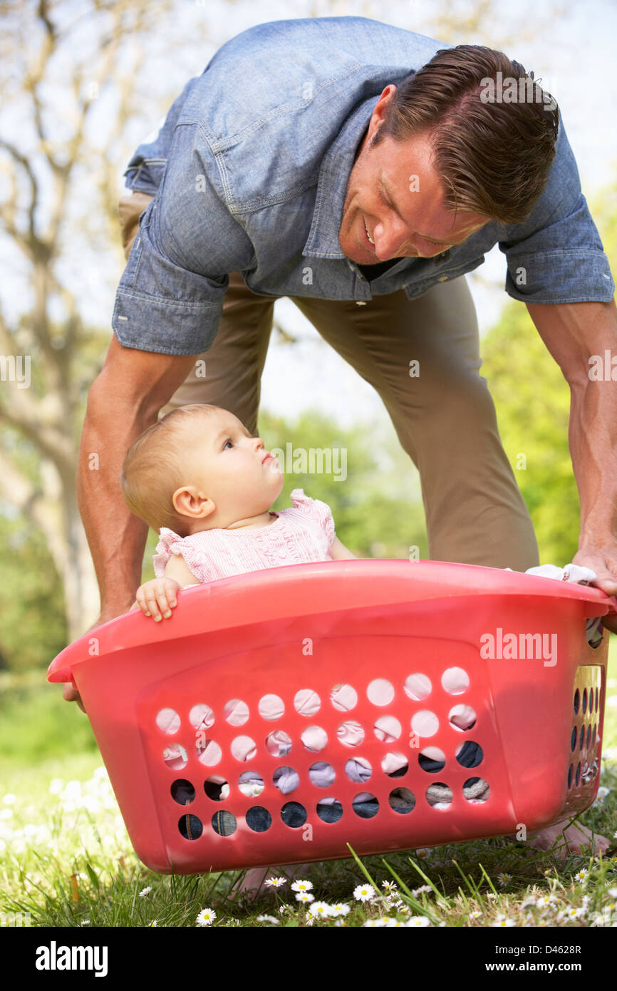 Father Carrying Baby Girl Sitting In Laundry Basket Stock Photo Alamy