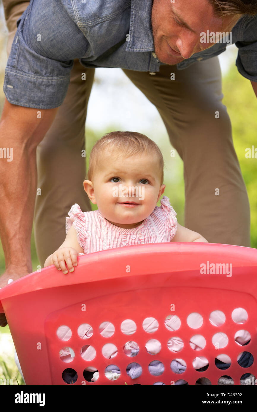 Father Carrying Baby Girl Sitting In Laundry Basket Stock Photo Alamy