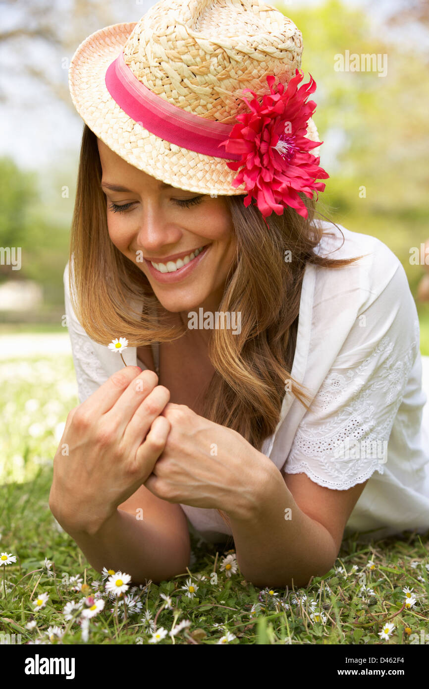 Woman Lying In Field Of Summer Flowers With Straw Hat Stock Photo - Alamy