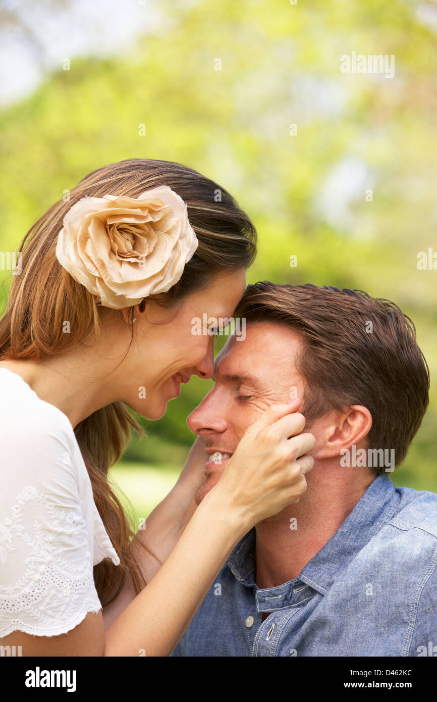 Romantic Couple Sitting In Field Of Summer Flowers Stock Photo