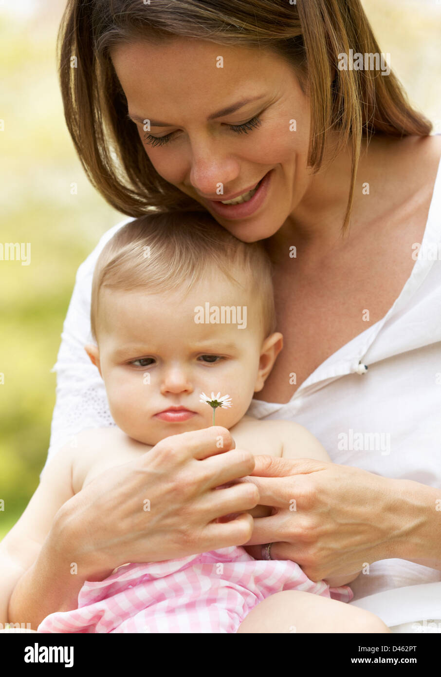 Mother Sitting With Baby Girl In Field Of Summer Flowers Stock Photo