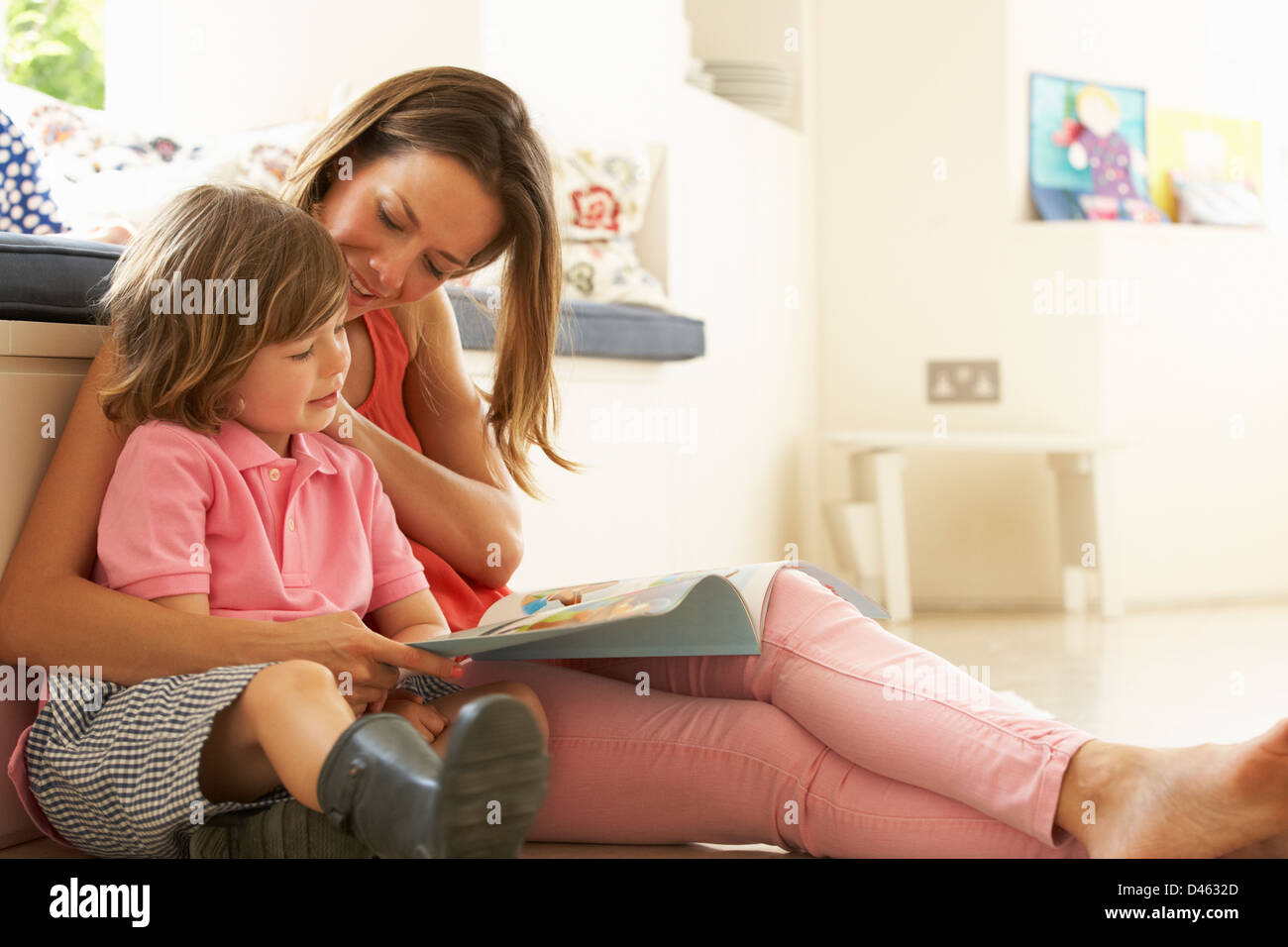 Mother Sitting With Son Reading Story Indoors Stock Photo