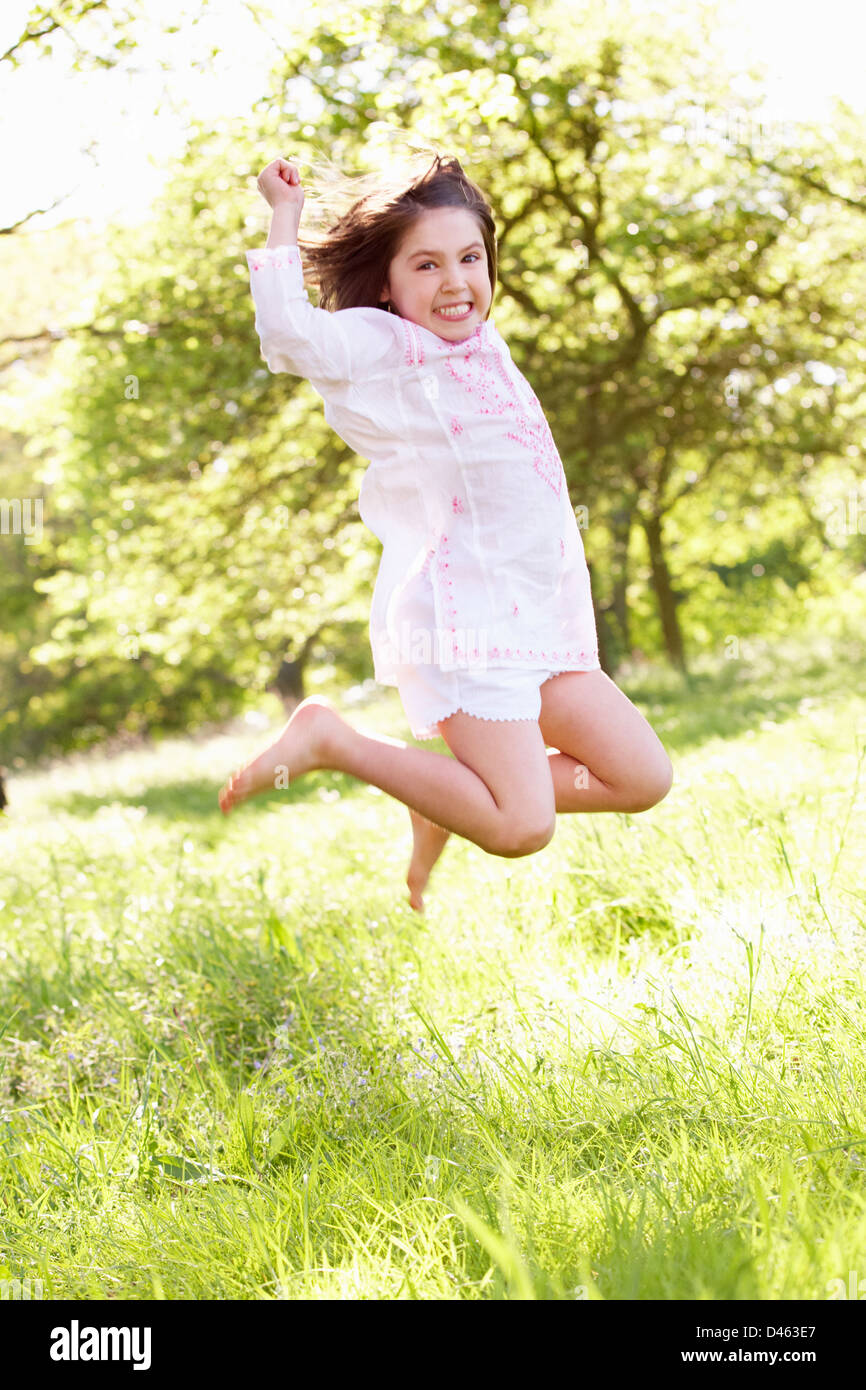 Young Girl Jumping In Summer Field Stock Photo
