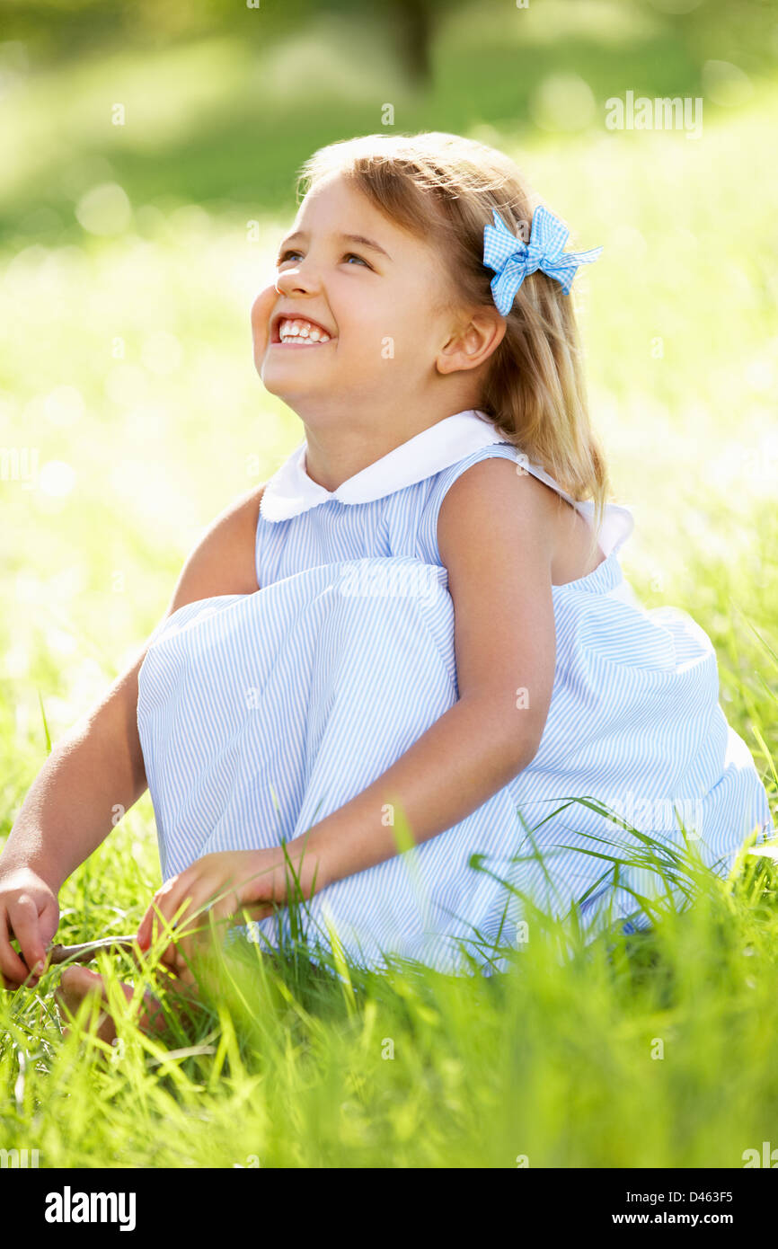 Young Girl Sitting In Summer Field Stock Photo