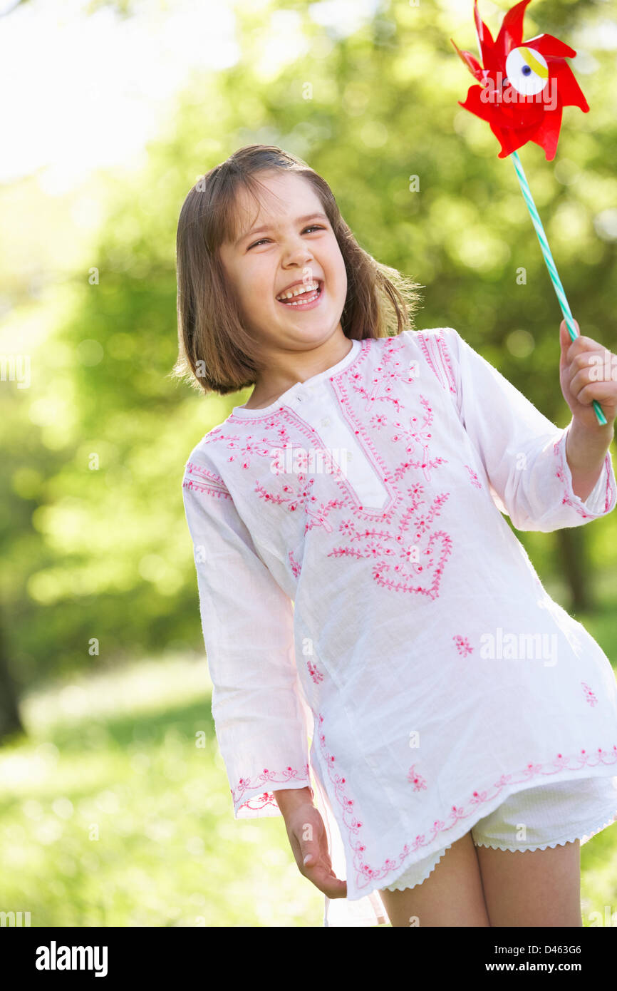 Young Girl Walking Through Summer Field Carrying Windmill Stock Photo