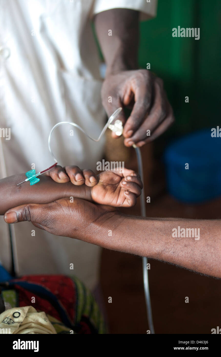 Central African Republic. August 2012. Batalimo for Congolese refugees. A male nurse helps put in drip to baby with malaria Stock Photo
