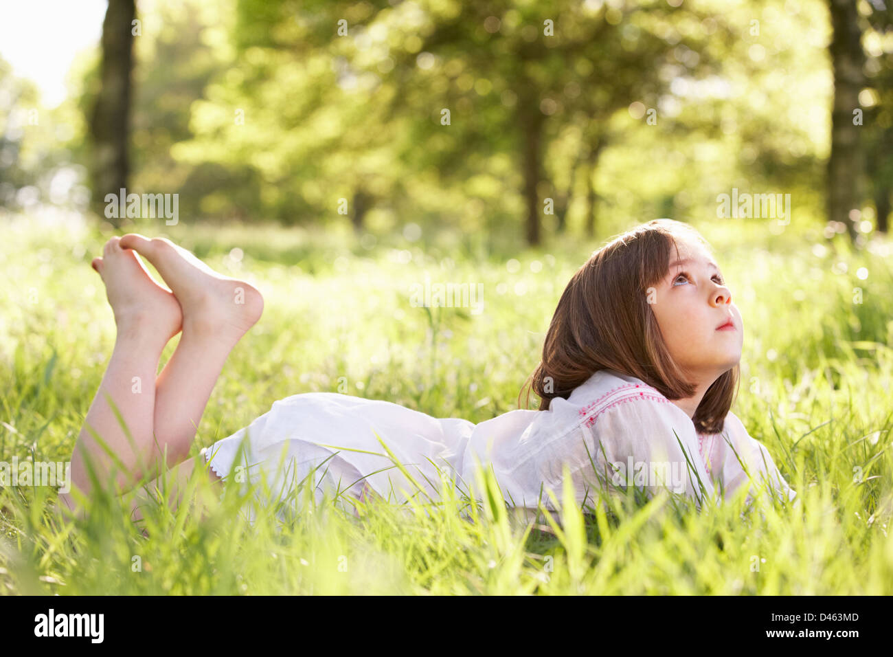 Young Girl Daydreaming Lying In Summer Field Stock Photo