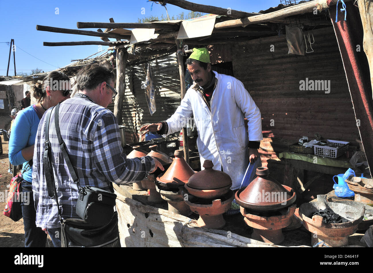 Holidaymakers choose which tagine they want to buy at the Friday Berber market in the village of Douar Boarova Aghmat, near  Marrakesh, Morocco Stock Photo