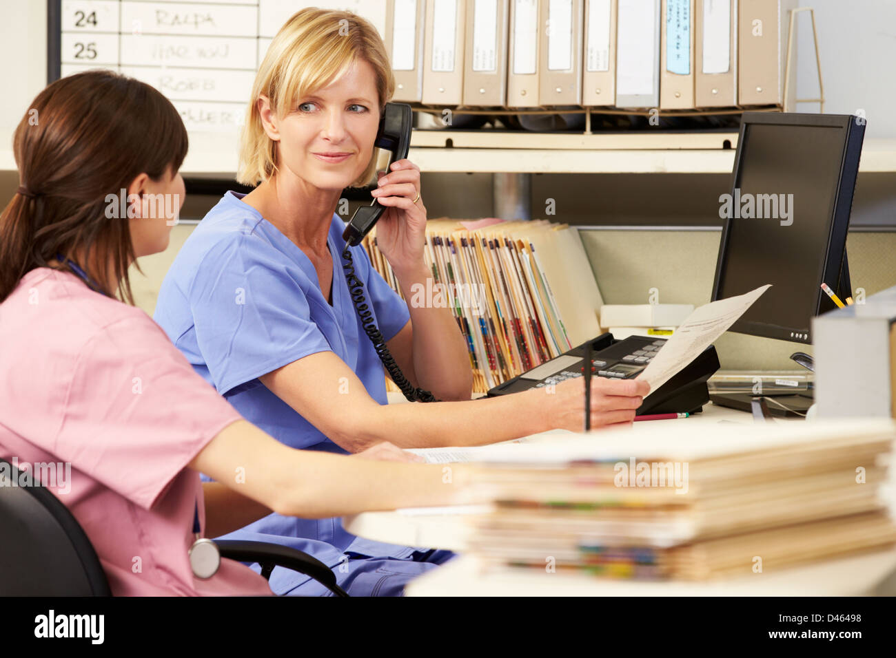 Two Nurses Working At Nurses Station Stock Photo Alamy