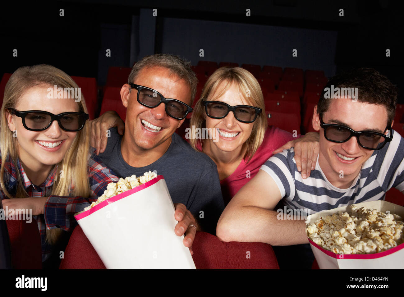Teenage Family Watching Film In Cinema Stock Photo