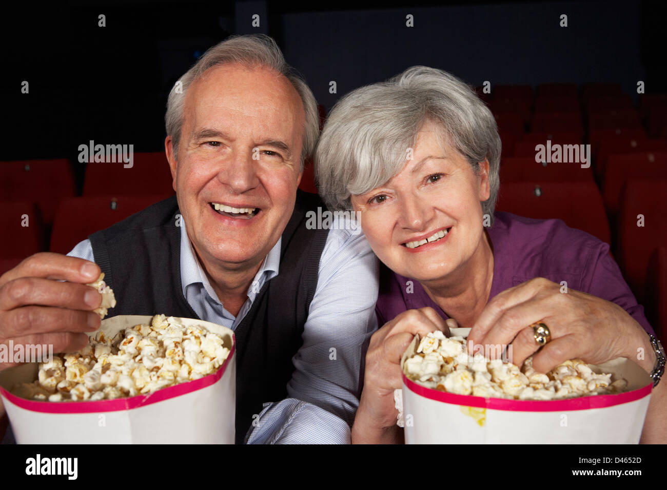 Senior Couple Watching Film In Cinema Stock Photo